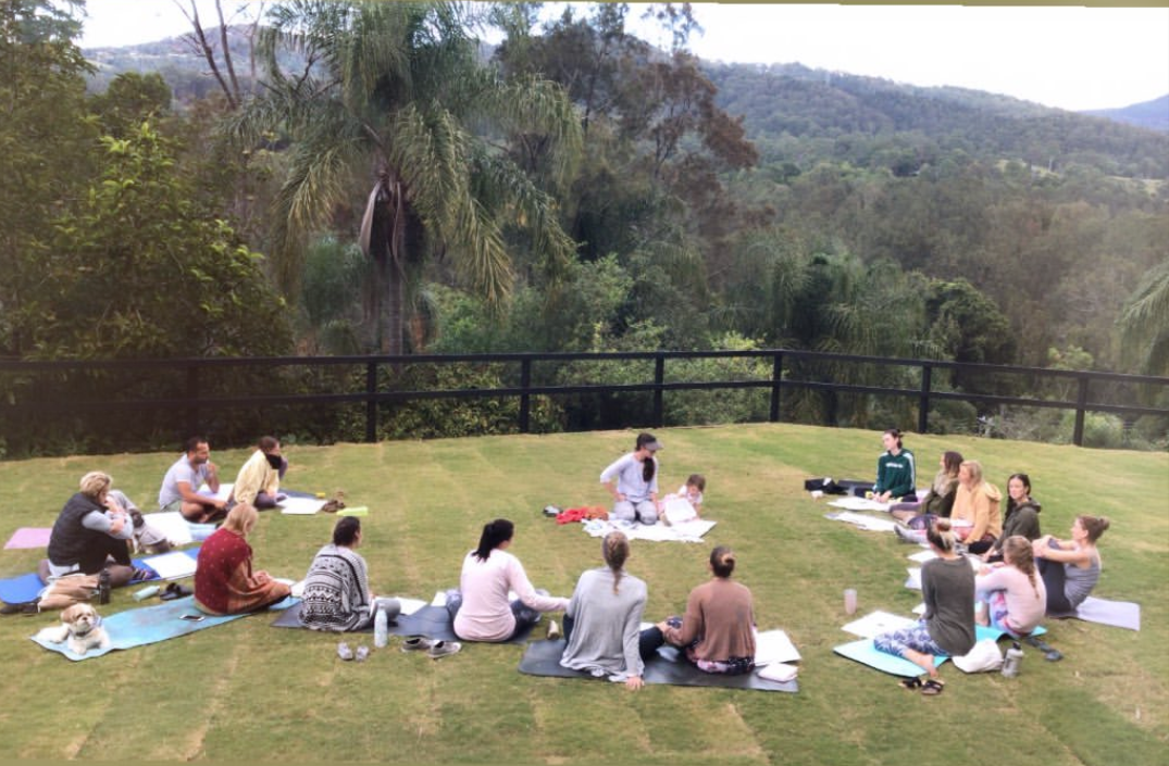 Yoga teacher training Essence of Living group learning on the grass